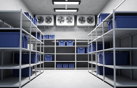 Refrigeration warehouse for food with metal shelves of frozen foods and boxes