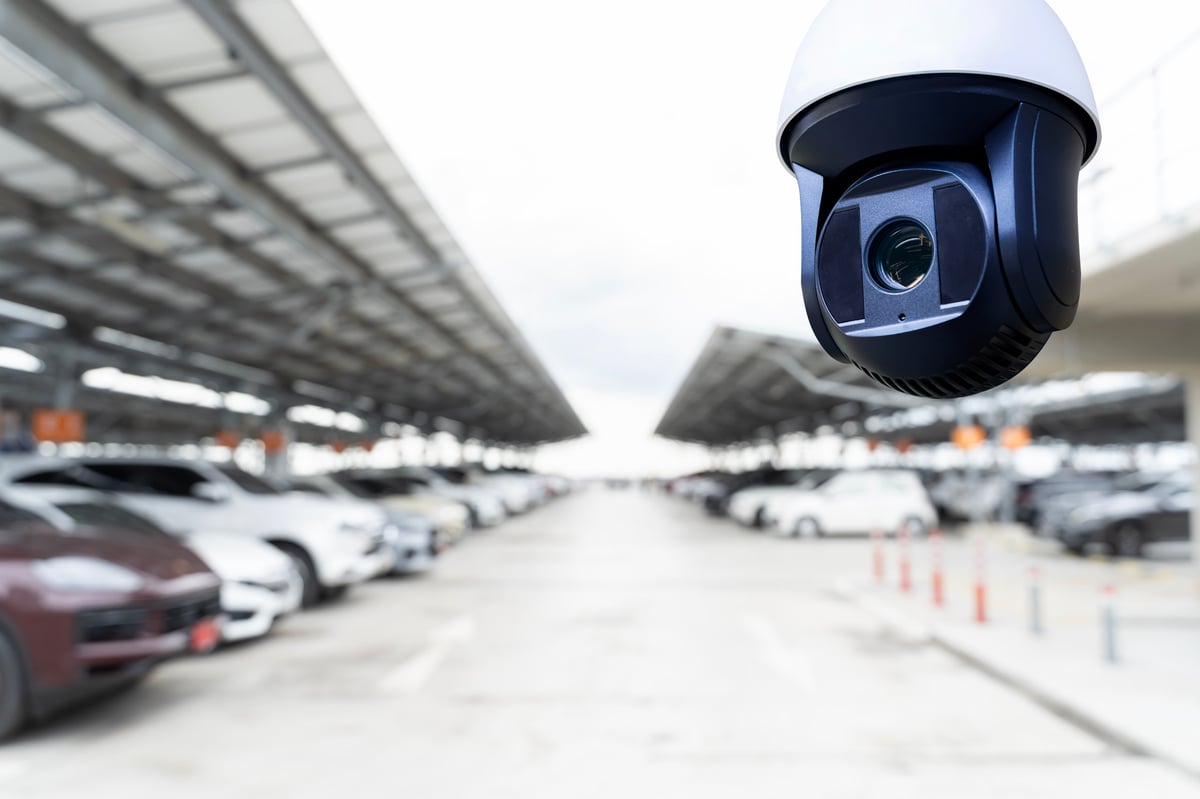 Modern parking lot with surveillance cameras and smart technology monitoring system
