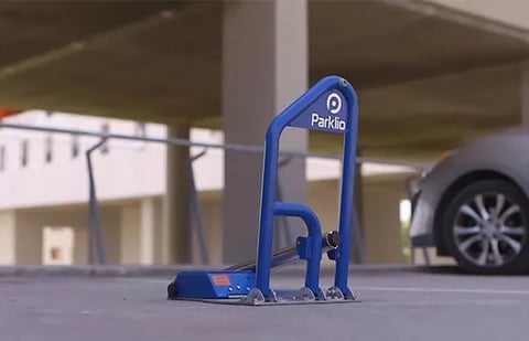 Blue Parklio parking barrier in a garage with a car visible in the background